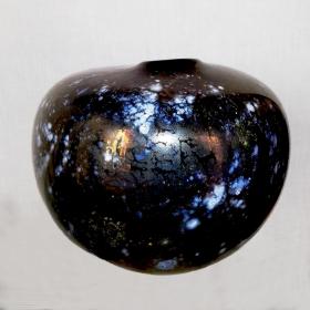 Angelo Rinaldi, Siria, Vaso scultura a forma sferica irregolare in vetro soffiato su colore neroframmenti in lattimo sparsi su tutua la superficie  con successiva iridazione, h.cm.20 x24, firma incisa, 1999