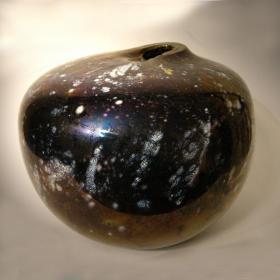 Angelo Rinaldi, Siria, Vaso scultura a forma sferica irregolare in vetro soffiato su colore neroframmenti in lattimo sparsi su tutua la superficie  con successiva iridazione, h.cm.20 x24, firma incisa, 1999